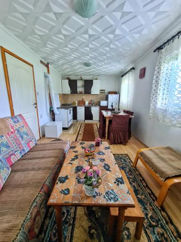 a living room with a table with flowers on it at Vikendica Jovanovic in Bajina Bašta