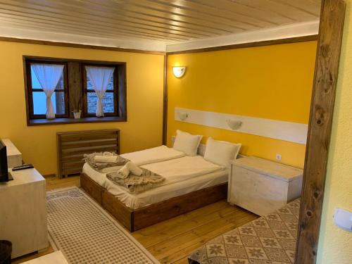 a small bedroom with a bed and a window at Family Hotel Byalata Kashta in Kovačevica