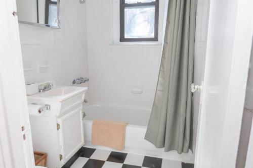 a bathroom with a white tub and a sink at Hoboken Haven – Heart of town! in Hoboken