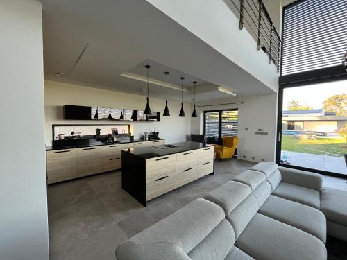 a living room with a couch and a kitchen at Luxury VIP Villa 230m2+Pool 37m2 in Nové Jirny