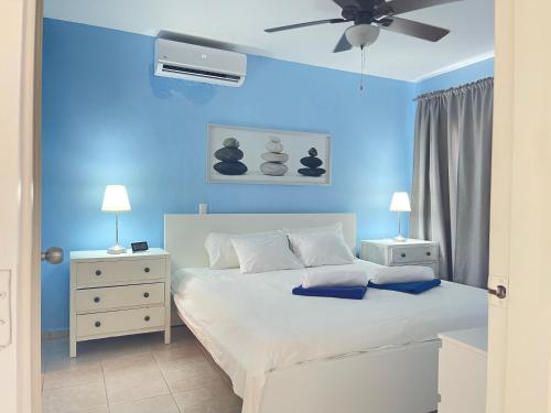 a blue bedroom with a bed and a ceiling fan at Stanza Mare Beach Front in Punta Cana