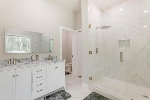 ein weißes Bad mit einer Dusche und einem Waschbecken in der Unterkunft Modern Decatur Home about 7 Mi to Atlanta! in Decatur