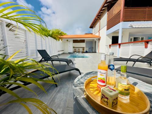 a tray with drinks on a table on a patio at Villa 2 chambres, Jacuzzi et Piscine in Maximin
