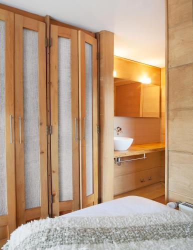 a bedroom with wooden cabinets and a white sink at Palafito 1326 Hotel Boutique Chiloé in Castro