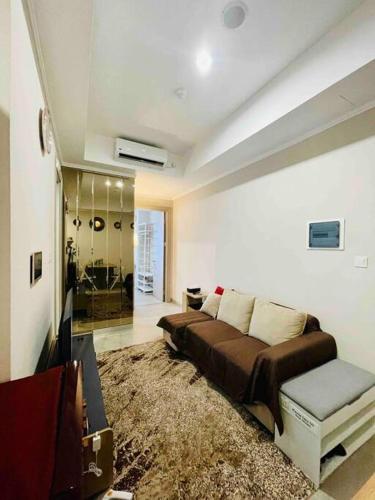 a living room with a bed and a television at [300m to PRJ] Expo Friendly 2BR in Jakarta