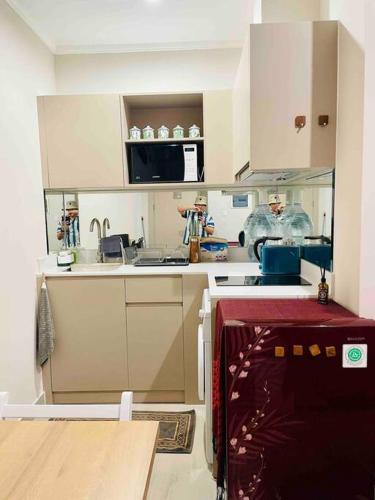 a small kitchen with white cabinets and a sink at [300m to PRJ] Expo Friendly 2BR in Jakarta