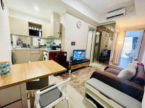 a living room with a couch and a table and a kitchen at [300m to PRJ] Expo Friendly 2BR in Jakarta