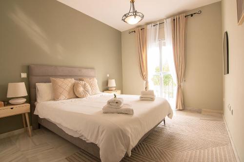 a bedroom with a large bed with towels on it at Luxury apartment in Miraflores in La Cala de Mijas