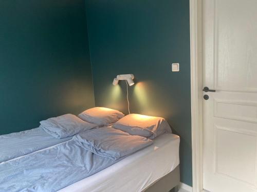 Cama en habitación con pared verde en Beautiful apartment with amazing view en Bergen