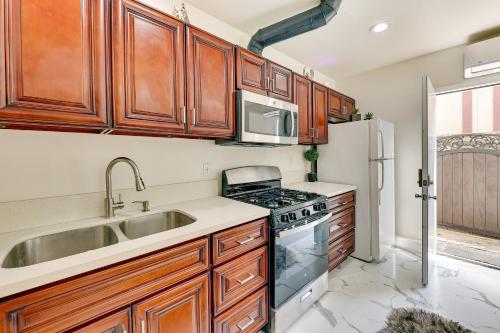 a kitchen with wooden cabinets and a sink and a stove at Anaheim Hills Retreat with Private Backyard and Pool! in Anaheim