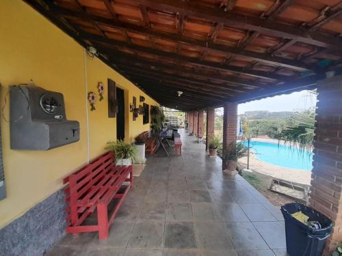 een veranda met een bank en uitzicht op een zwembad bij Chácara Recanto do Sol in Mogi das Cruzes