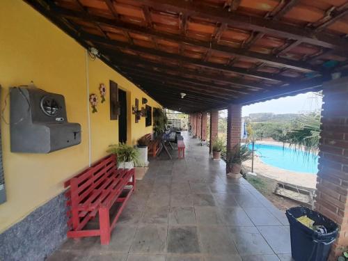 a porch with a bench and a view of a pool at Chácara Recanto do Sol in Mogi das Cruzes