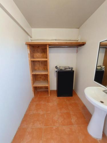 een badkamer met een wastafel, een toilet en een plank bij Estudios Del Mar km42 in Raulis