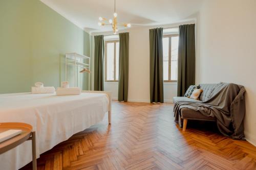 um quarto com uma cama, uma cadeira e janelas em Casa Settefontane em Trieste