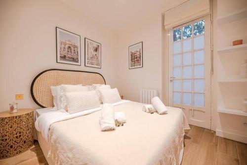 - une chambre avec un grand lit blanc et des oreillers blancs dans l'établissement Cosy Home in Haut Marais II, à Paris