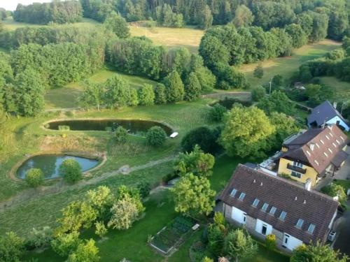 an aerial view of a house in a field with a pond at Apartmány Braníčkov in Branickov