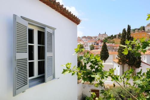 an open window on a white building with a view at Hotel Leto Hydra in Hydra