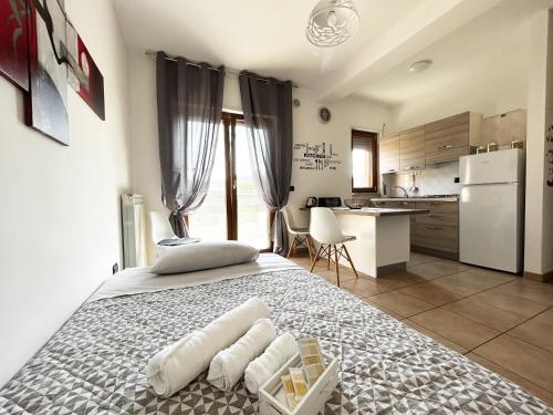 a bedroom with a large bed and a kitchen at Sunrise Home in Cosenza