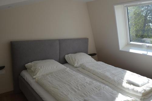 a bed with two white pillows and a window at Holiday Home Mooi-Gemmenich in Plombières