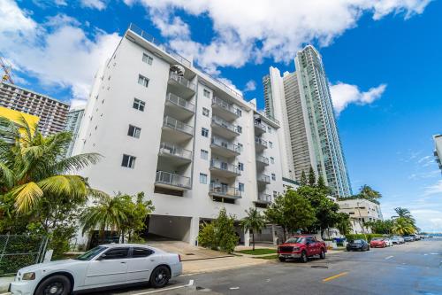 a white building with cars parked in front of it at Subtle 2 Bed in Edgewater Downtown with Free Parking in Miami