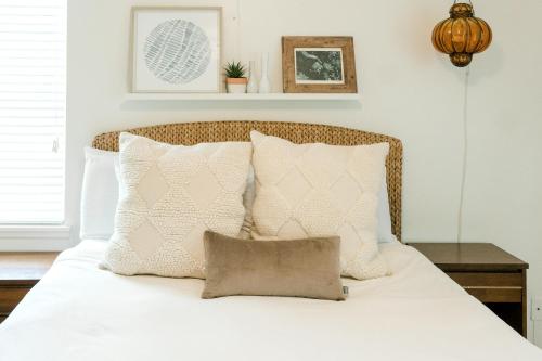 een slaapkamer met een bed met witte lakens en kussens bij Follow the Leader in Houston