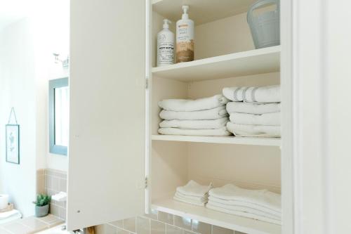 een badkamer met witte handdoeken op een plank bij Follow the Leader in Houston