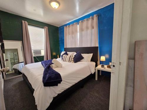 ein Schlafzimmer mit einem großen Bett mit blauen Wänden in der Unterkunft Bungalow King n Queen Bed 5m Wynwood Kitchen in Miami