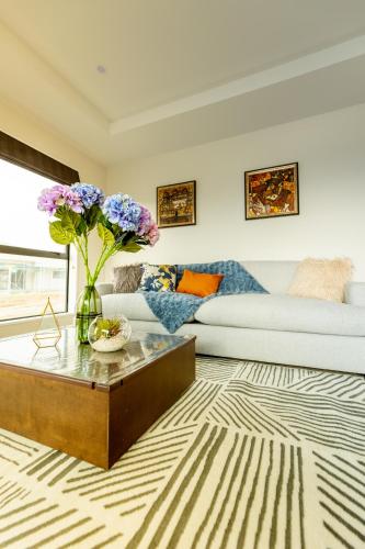 a living room with a couch and a table with flowers at Crescent Moon in Lake Tekapo