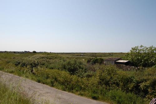a field with a building in the middle of a road at Le Parc des Mimosas in Noirmoutier-en-l'lle