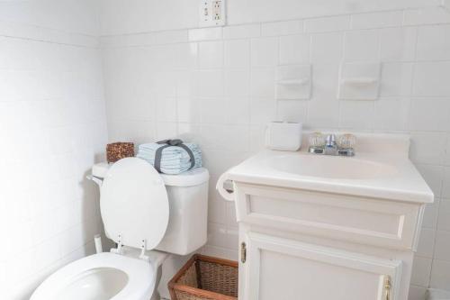 a white bathroom with a toilet and a sink at Wonderful stay – Heart of Hoboken in Hoboken