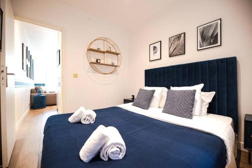 une chambre avec un lit bleu avec des serviettes dessus dans l'établissement Nice flat in the Marais I, à Paris