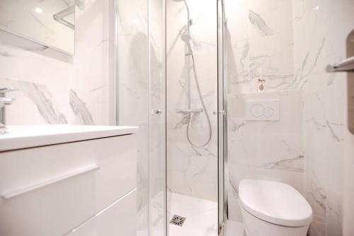 une salle de bain blanche avec douche et toilettes dans l'établissement Nice flat in the Marais I, à Paris