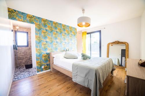 1 dormitorio con cama y espejo en New Villa Oasis- Clim- Piscine privé- Cosy- famille TOP PROS SERVICESCONCIERGERIE, en Saint-Gély-du-Fesc