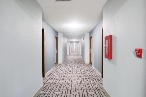 a long corridor with white walls and a carpeted hallway at Baymont by Wyndham Flint Airport North in Flint