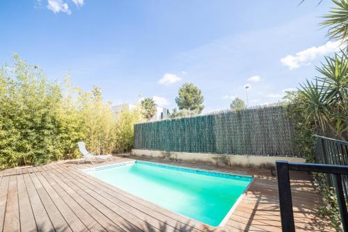 a swimming pool with a chair on a wooden deck at New Villa Oasis- Clim- Piscine privé- Cosy- famille TOP PROS SERVICESCONCIERGERIE in Saint-Gély-du-Fesc