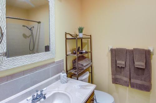 a bathroom with a sink and a toilet and a mirror at Overland Park Home with Fenced-In Yard and Gas Grill! in Overland Park