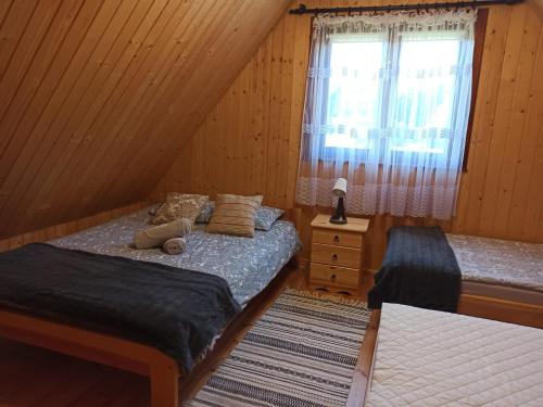 1 Schlafzimmer mit 2 Einzelbetten und einem Fenster in der Unterkunft Agroturystyka Uroki Roztocza in Zamość