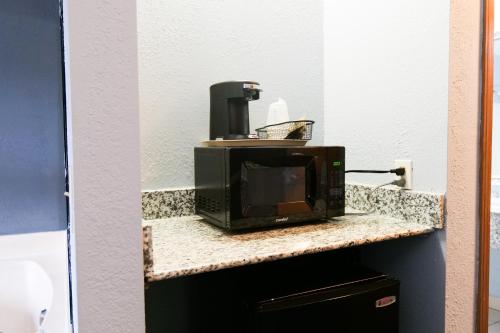 a microwave sitting on top of a counter at Baymont by Wyndham Flint Airport North in Flint