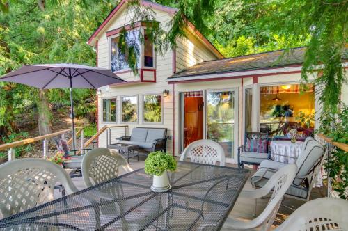a table with chairs and an umbrella on a patio at Lakefront Snohomish Cottage with Private Dock! in Snohomish