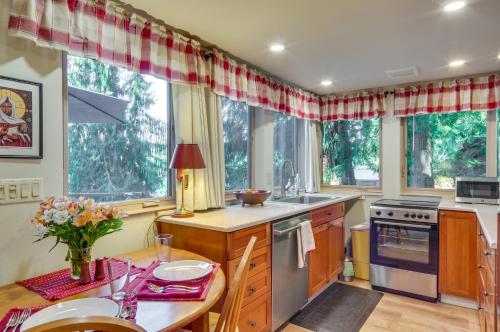 a kitchen with a table and some windows at Lakefront Snohomish Cottage with Private Dock! in Snohomish