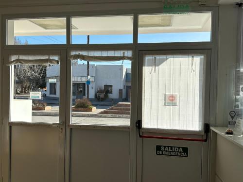 a glass door with a view of a building at Hotel Kelman in Perito Moreno
