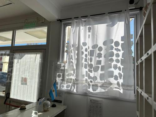 a window with a curtain in a room at Hotel Kelman in Perito Moreno