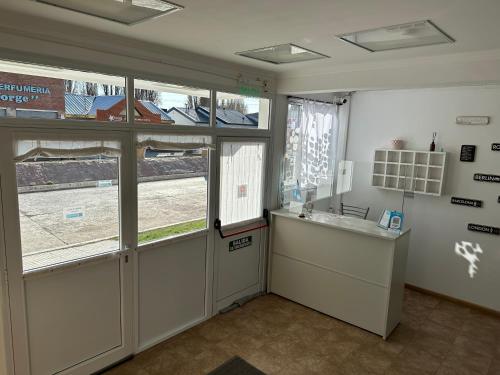 a room with a door and a counter and windows at Hotel Kelman in Perito Moreno
