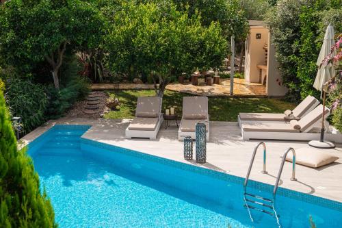 a swimming pool with two lounge chairs and a swimming pool at Villa Komfort in Zakynthos