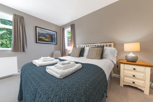 a bedroom with a bed with towels on it at Colt Park Cottage in Ulverston