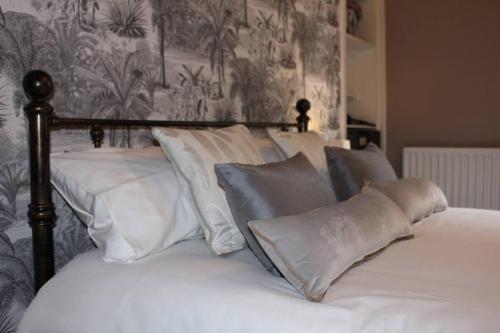 Una cama con sábanas blancas y almohadas. en Cameronian Apartment, en Stirling