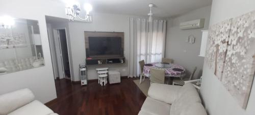 uma sala de estar com um sofá e uma mesa em Apartamento 2 quartos aconchegante em Santos