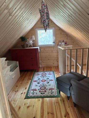 a attic room with a staircase and a rug at Chatka Jezioranka & bania in Kolonia Siedlątków