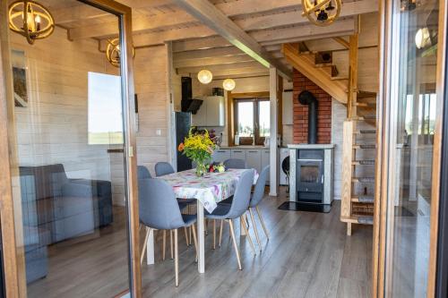 a dining room with a table and chairs and a fireplace at BANIA NA CZASIE in Szyldak