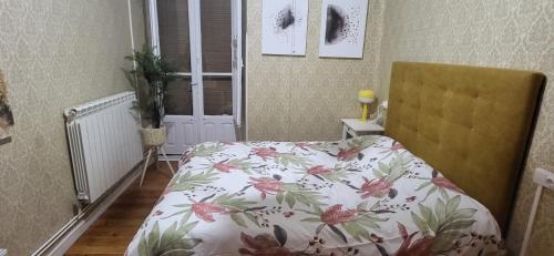 a bedroom with a bed with a floral bedspread at EL BALCÓN DE LA PLAZA. in Arévalo